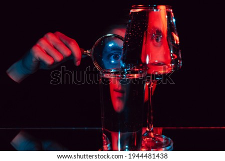 surreal portrait of a man looking through a magnifying glass and glass glasses with water