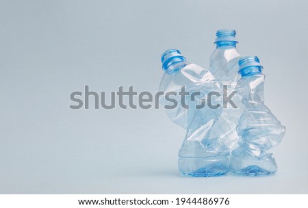 Used crushed pet plastic bottles on blue background, recycling and environment concept copy space Royalty-Free Stock Photo #1944486976