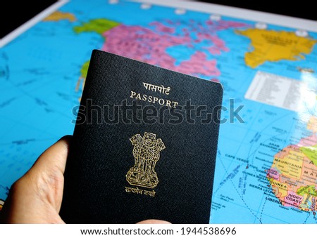 Image of a persons hand holding a passport with map in the background