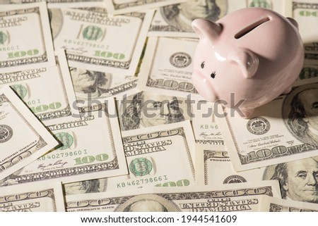 Overhead photo of piggybank pink pig with money dollars cash on the background isolated