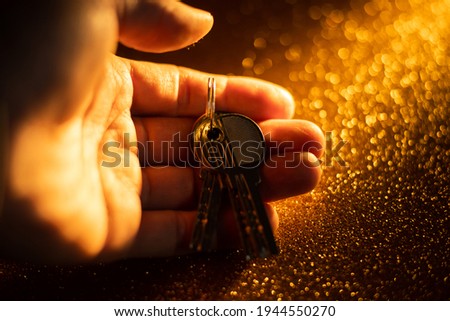hand holding keys. man taking key to the new home. Male holding keys from new apartment. Light background. Keys concept.