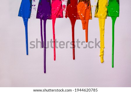 blue ,purple, pink, red,orange, yellow and green are slowly dripping from color scoop handle.
and slowly spread onto the white paper. 