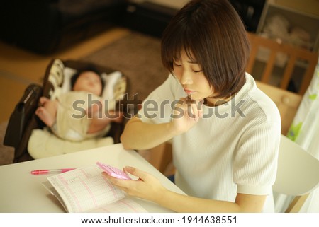 Mother keeping a household account book  Royalty-Free Stock Photo #1944638551