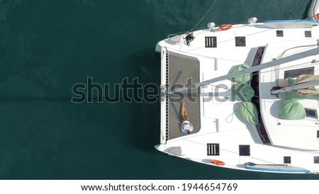 A man enjoys a vacation on a sailing yacht, a man on board a sailing catamaran takes a selfie from a drone Royalty-Free Stock Photo #1944654769