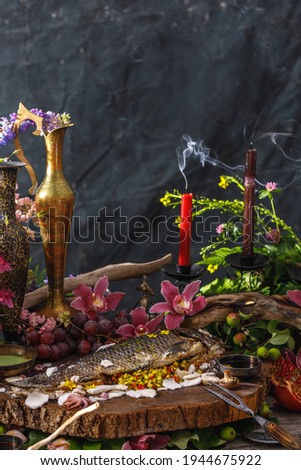 Still life in masters style with fish, glass of wine, old dishes, fruits. The concept of a richly decorated table.
