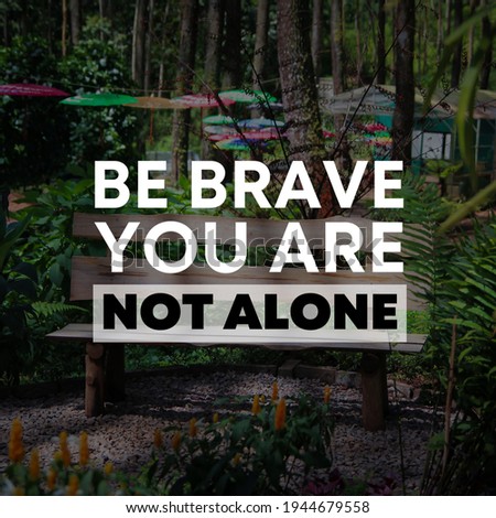 Be brave you are not alone. Quote on empty bench among th pine trees background.