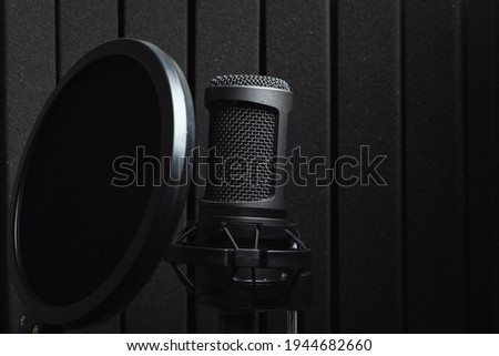 Black studio microphone with acoustic foam with pop filter