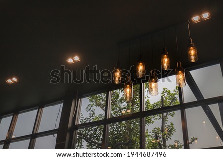 Glowing light bulbs hanging from ceiling, stock photo