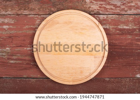 Cutting board for cutting bread, pizza or steak on a wooden background. Top view.