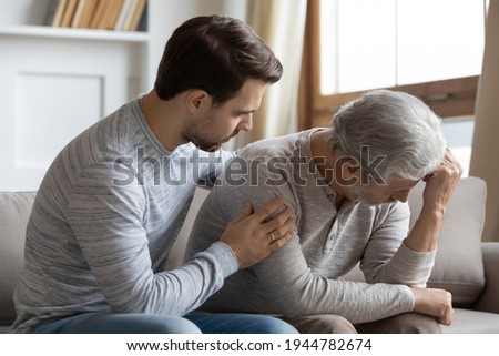 Caring millennial adult man hug caress sad unhappy elderly 60s father felling lonely abandoned. Loving grownup son comfort support mature dad, make peace reconcile after family fight quarrel. Royalty-Free Stock Photo #1944782674