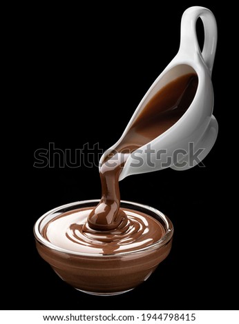 Pouring melted chocolate cream on black background Royalty-Free Stock Photo #1944798415