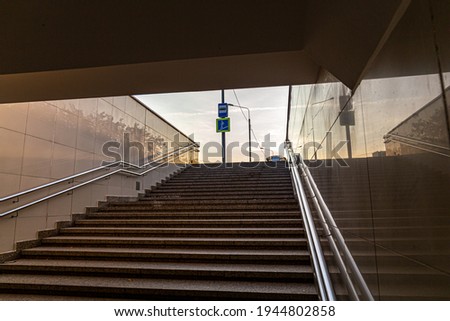 underpass staircase and road sign on background of sky, bottom view