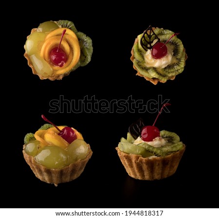 Fruit dessert cake with cherries, a leaf of chocolate, kiwi slices and protein cream on a black background isolated, collage