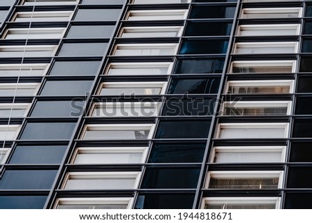 The facade of the building in the perspective of the modern type.Selective focus. Linney walls and windows, symmetrical photography. Finishing materials in construction. Business Centre. 
