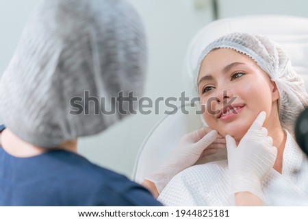 A beautician doing beauty treatment for young woman laying down and relaxing in a beauty clinic ,concept for beauty business advertising Royalty-Free Stock Photo #1944825181