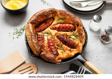 Toad in the hole, Sausage Toad, traditional English dish of sausages in Yorkshire pudding batter.  Royalty-Free Stock Photo #1944828409