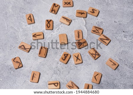 Scandinavian magic runes made of oak on concrete