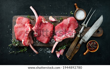 Raw veal meat ribs cutlets with ingredients on rustic dark background, top view. Frenched Racks meat Royalty-Free Stock Photo #1944892780
