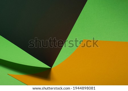 Colour paper geometric shape. Green and yellow paper with shadow effect and selective focus. Abstract background. Copy space.