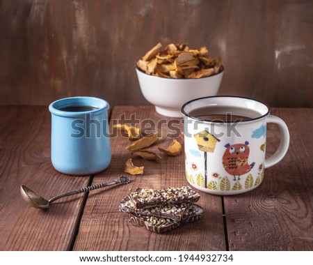 Delicious sweet lunch with apple chis and apple syrup, tea in a large mug with a pattern on a wooden toe cap Royalty-Free Stock Photo #1944932734