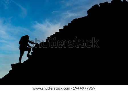 Young male tourists climbing mountains Ideas for personal development and goals in the life of a climber with a backpack. Royalty-Free Stock Photo #1944977959
