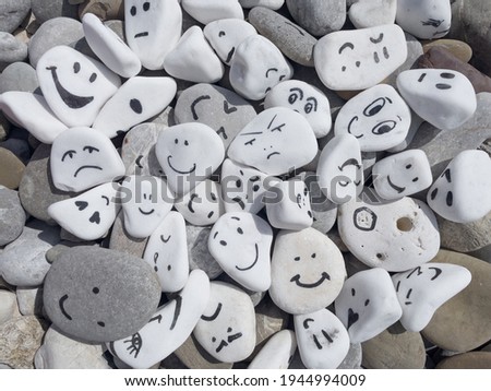 Emotion management concept, stones with painted faces symbolize different emotions. We are all different, but all together, learning to manage emotions. Emotional intelligence, role model. Good mood. Royalty-Free Stock Photo #1944994009