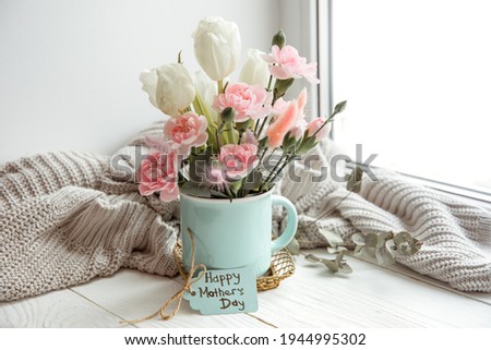 Spring still life with flowers in a vase and the inscription Happy Mother's Day on the postcard.