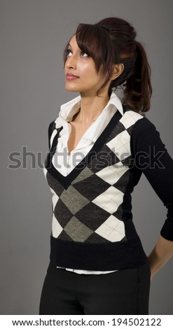 Indian businesswoman looking up with hands behind back