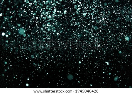 Bright and dark aqua green blue blur bokeh circle on black background for your design.
