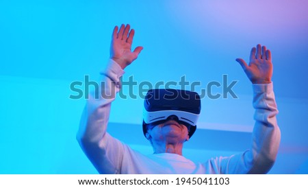 Retired elderly woman wearing VR glasses. Scared from something in virtual reality . High quality photo