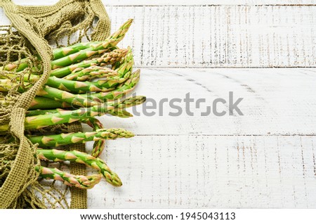 Asparagus. Fresh green asparagus bunch ready for cooking on white old wooden background. Top view copy space.