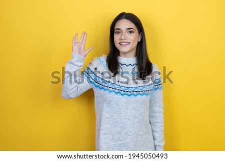 Young caucasian woman wearing casual sweater over yellow background doing hand symbol