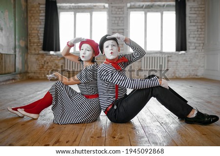 Male and female mime artists sitting on the floor