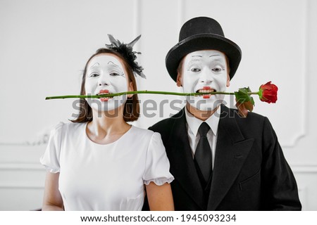 Two mime artists, love couple with rose in teeth