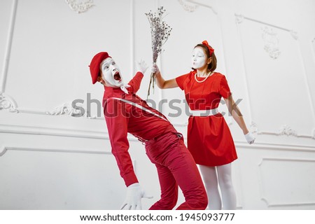Mime artists in red costumes, scene with bouquet