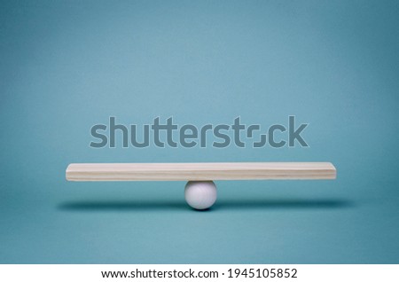 Stability, balance and equality in business partnerships in economic relations. Business finance concept. Wooden scale on a turquoise background. Royalty-Free Stock Photo #1945105852
