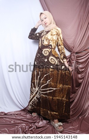 Asian woman wearing batik dress posing in the studio