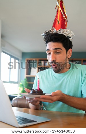 Man celebrating birthday online from home.