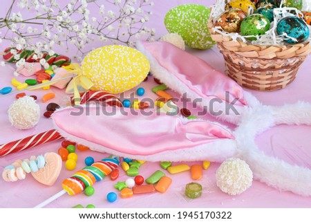 Easter composition with sweets, rabbit ears and tulips.