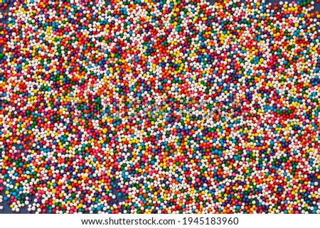 Edible sugar sprinkles background - red, white, blue, green and purple rounds sugar confetti. Seamless pattern.
