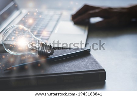 Laptop with glowing light bulb and textbook. Self learning or education knowledge and business studying concept. Idea of learning online or e-learning from home.