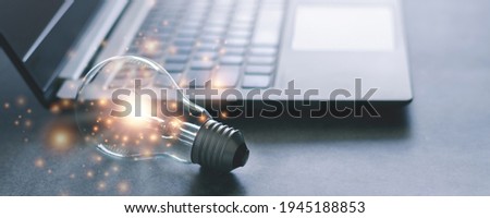 Laptop and glowing light bulb. Self learning or education knowledge and business studying concept. Idea of learning online or e-learning from home. Royalty-Free Stock Photo #1945188853