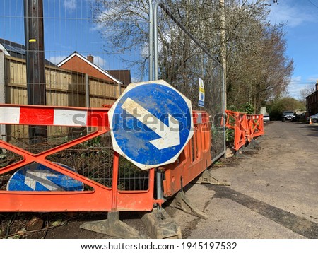 View of construction sign on road side for background use. Space to add text on blurry road surface near the work sign. Road maintenance, health and safety, transport industry concept.