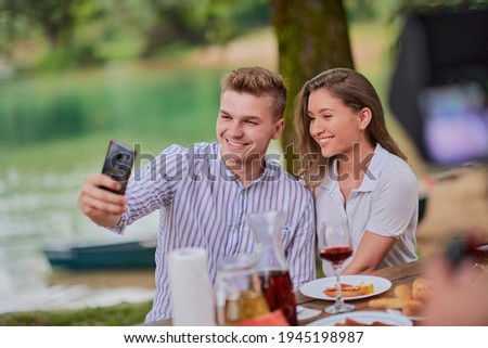 couple taking selfie while having picnic french dinner party outdoor