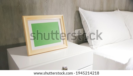close up of photo frame with green copy space on cabinet in bedroom at home