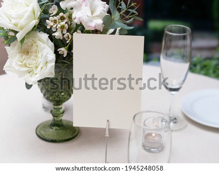Mockup white blank space card, for greeting, table number, wedding invitation template on wedding table setting background. with clipping path Royalty-Free Stock Photo #1945248058
