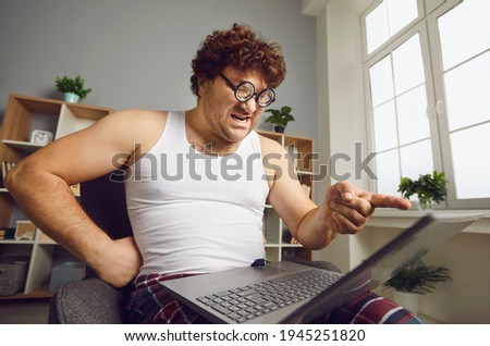Someone's Wrong On The Internet. Funny angry man points finger at laptop screen. Aggressive opponent, online fight, discussing politics, disagreement, computer bug error, slow wifi connection concept Royalty-Free Stock Photo #1945251820