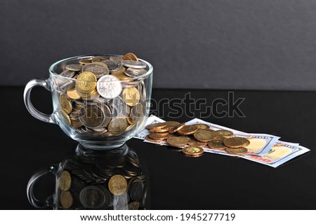 Coins in a cup and fake paper money. Business concept. Selective focus points. Blurred background