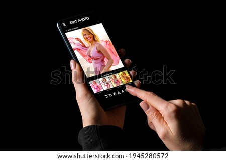Woman editing her photos on mobile phone, applying different photo filters to an image
