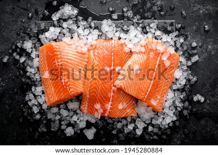 Salmon fillet. Slices of fresh raw salmon fish on ice Royalty-Free Stock Photo #1945280884